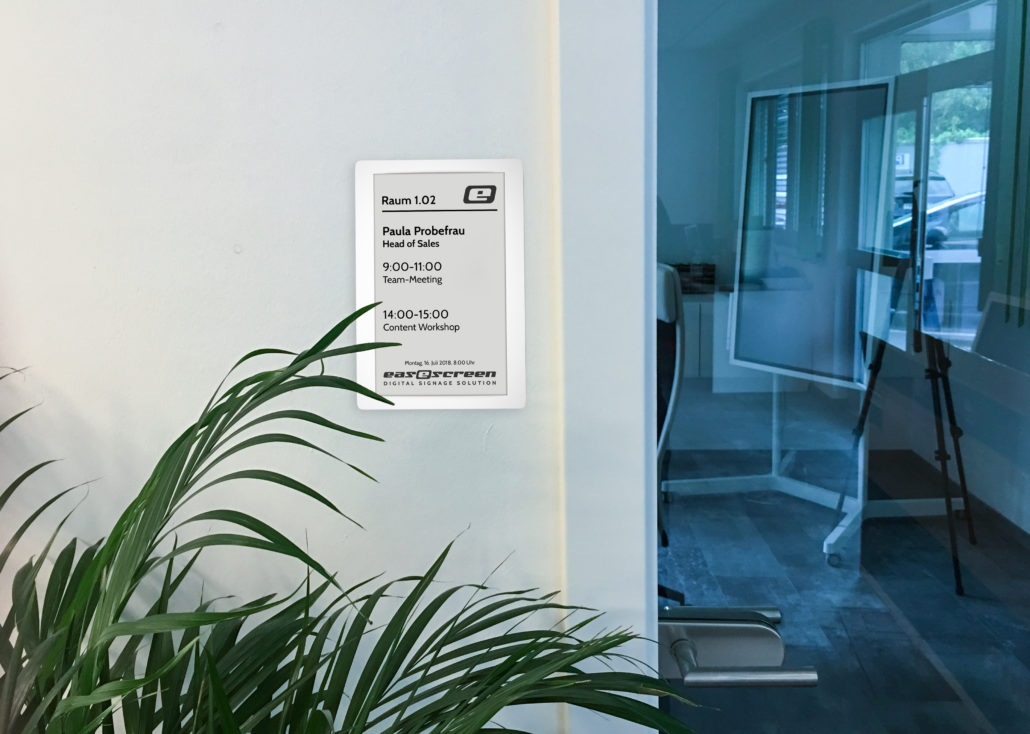 easescreen eSign eInk Türschild neben einer Glastür, Anwendungsbeispiel des Herstellers
